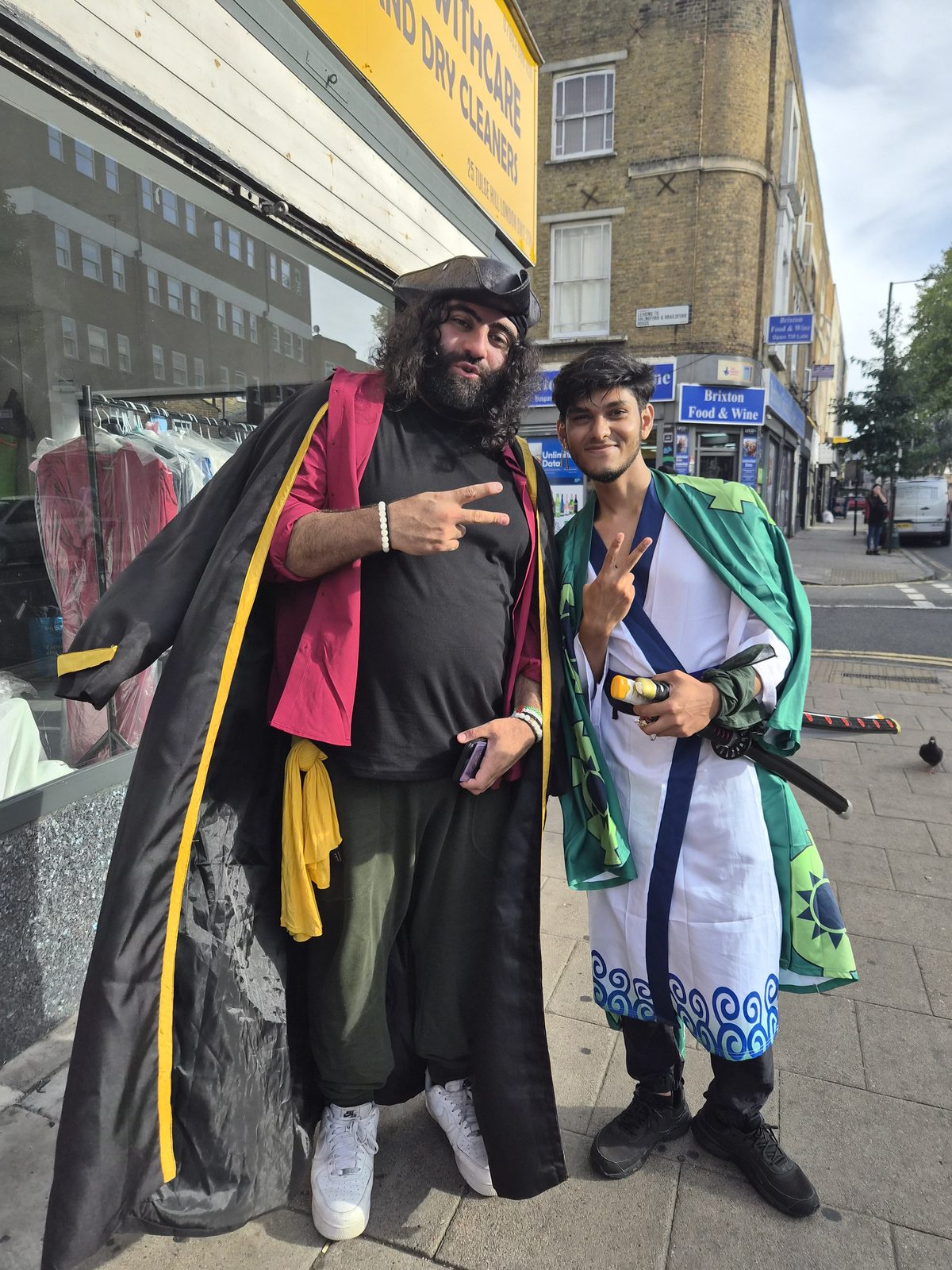 Two attendees in samurai-style cosplay posing on a London street at Cosplay for a Cause