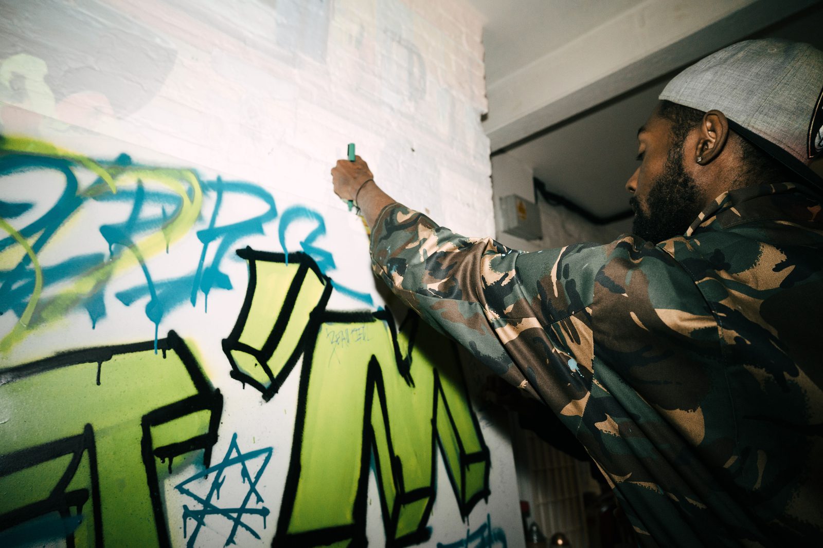 An attendee spray-painting graffiti art at the Self Love Special event