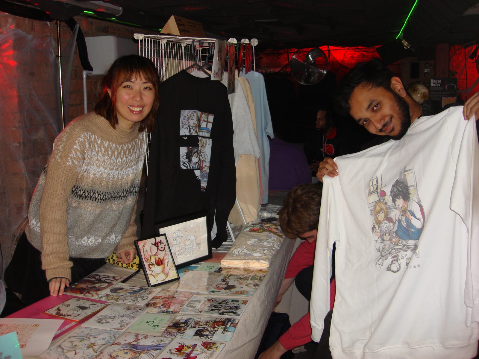 Artists showing off merch and prints at an exhibition table