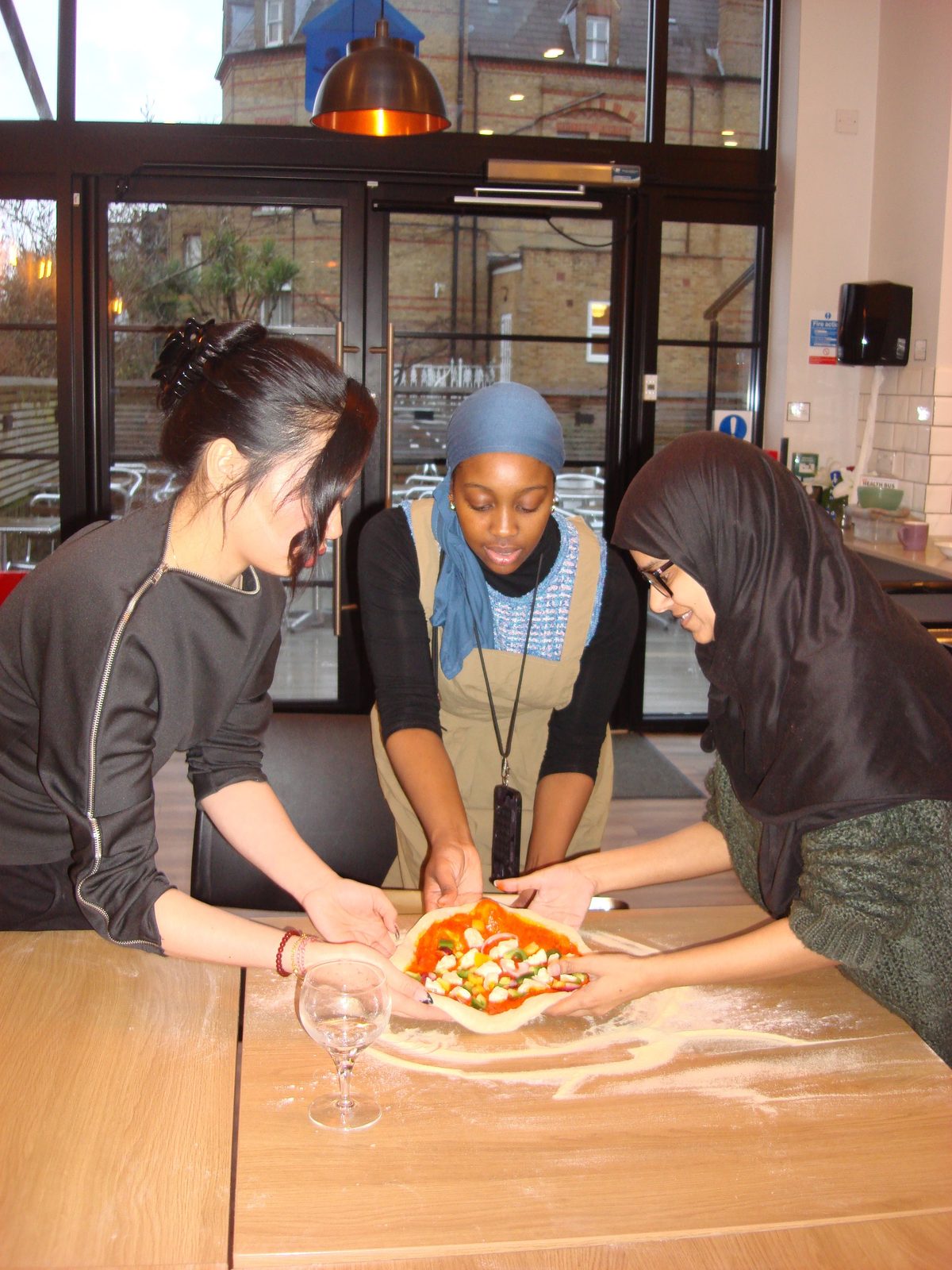 Attendees making pizza together at a workshop